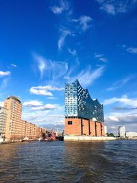 Buildings in city against cloudy sky