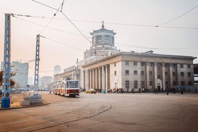 Street by buildings in city against sky