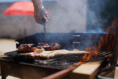 Cropped image of man preparing food on barbecue grill