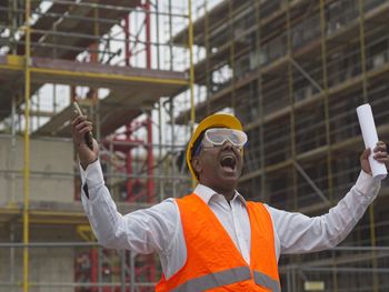 Portrait of young man standing against building