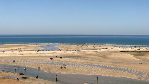 Scenic view of beach against clear blue sky