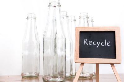 Bottles with recycle text on chalkboard against white background