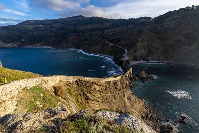 Scenic view of sea and mountains against sky