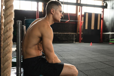 Shirtless man exercising in gym