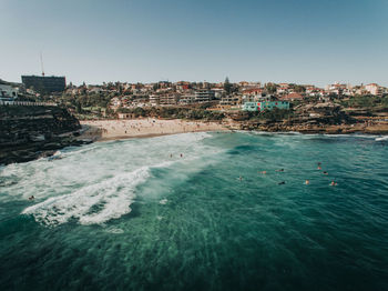 Scenic view of sea and buildings against clear sky