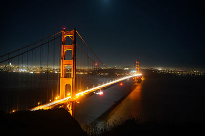 Illuminated suspension bridge at night