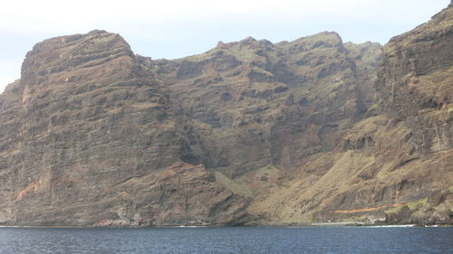 Scenic view of sea and mountains against sky