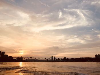 Bridge over river against sky during sunset