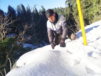 Full length of man holding snow on field