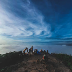 Group of people enjoying on land against sky