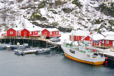 Boats moored by buildings during winter