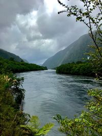 Scenic view of river amidst mountains against sky