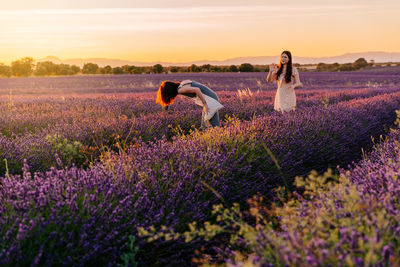 Full length of women standing on flower field