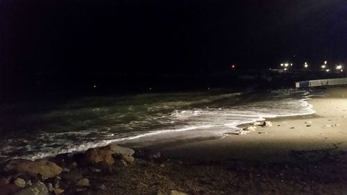 Illuminated sea against sky at night