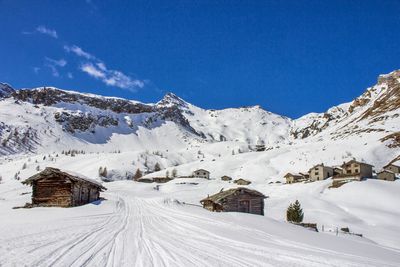 Scenic view of snowcapped mountains against blue sky