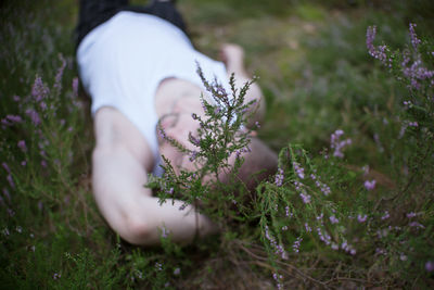 Low angle view of woman amidst flowering plants on field