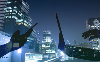 Illuminated buildings in city against sky at night