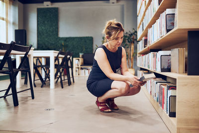 Woman choosing book in public library. selecting books. searching for literature for reading. relax