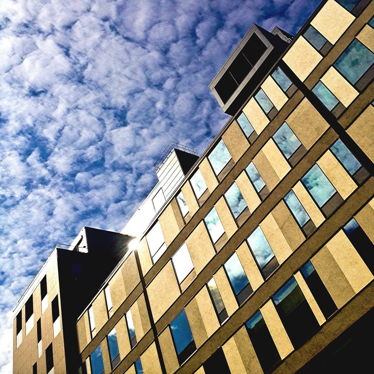 architecture, building exterior, built structure, low angle view, sky, city, window, building, modern, cloud - sky, office building, cloudy, skyscraper, glass - material, reflection, residential building, day, tall - high, cloud, outdoors