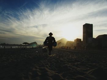 Rear view of man on beach against sky