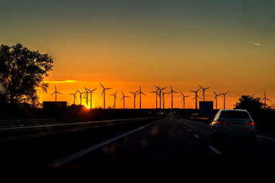 Cars on road against sky during sunset