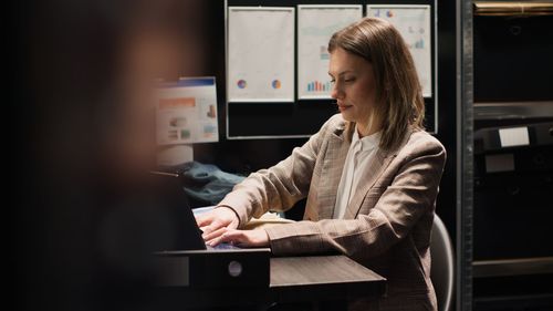 Portrait of young woman using laptop at office