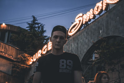 Low angle view of man standing by illuminated building