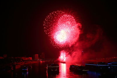 Firework display over river at night