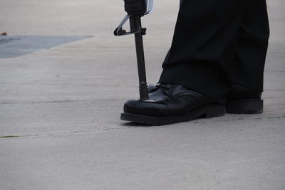 Low section of man standing on road