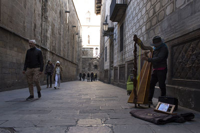 People walking on footpath amidst buildings in city