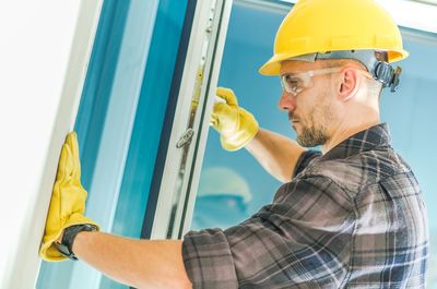 Side view of manual worker working by window