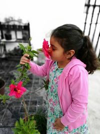 High angle view of girl smelling flower