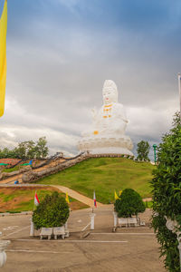 Statue against temple against sky