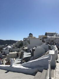 Buildings in city against clear blue sky