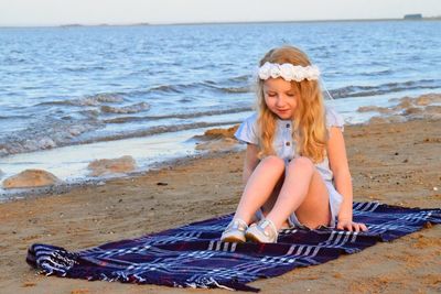 Girl sitting at beach during sunset