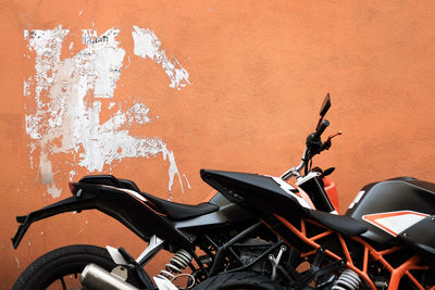 Motorcycles parked against orange wall