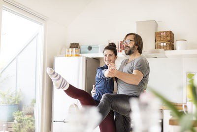 Smiling couple dancing in kitchen