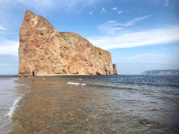 Rock formation on sea against sky