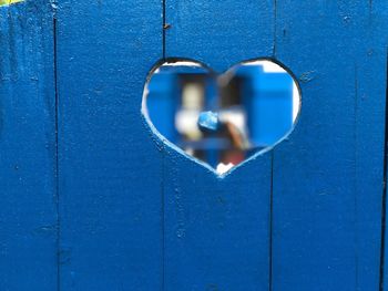 Close-up of heart shape hole on wooden wall