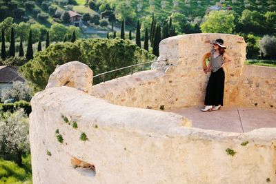 Woman wearing hat standing on old ruin