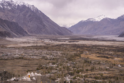 Scenic view of snowcapped mountains against cloudy sky