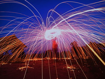 Low angle view of fireworks against sky at night