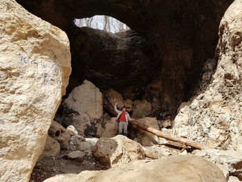 Rear view of people standing in cave