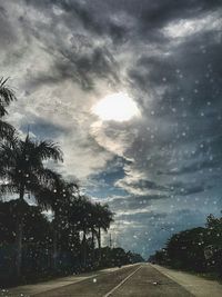 Empty road against cloudy sky