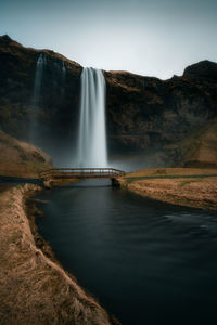 Scenic view of waterfall against sky