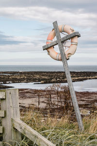 Traditional life bouy on beach against sky