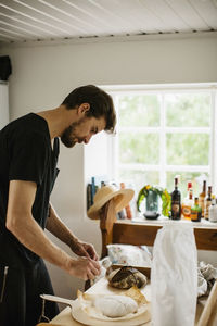 Man holding food while standing on table