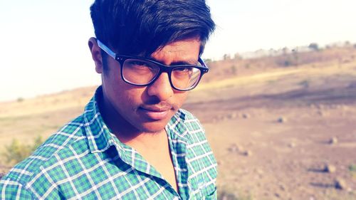 Portrait of young man wearing eyeglasses on field