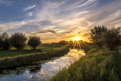 Scenic view of river against sky during sunset