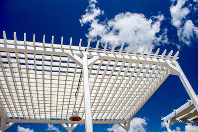 Low angle view of metallic structure against blue sky on sunny day